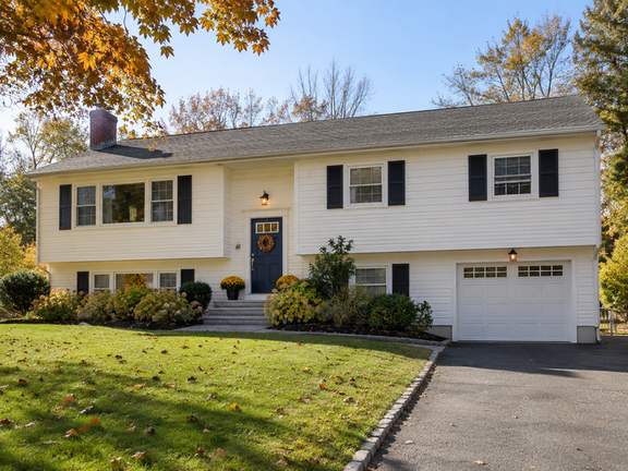 Warm white home with contrasting front door — Connecticut residential design inspiration