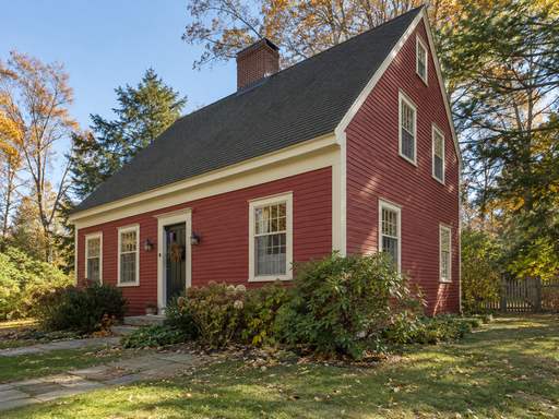 A red clapboard saltbox with cream trim — Connecticut residential design inspiration
